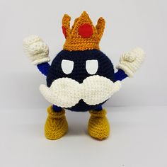 a crocheted stuffed animal with a crown on it's head and arms