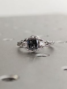 an engagement ring with a fancy black diamond