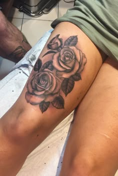 a woman's thigh with a rose tattoo on her left leg and the other side