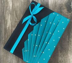 a black and blue book with white polka dots on it, wrapped in a ribbon