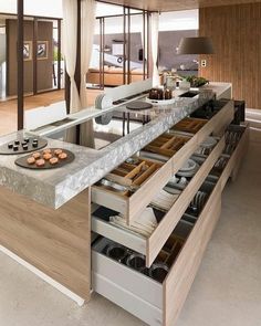 a kitchen with an island that has drawers in it and food on the counter top