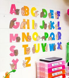 a classroom wall decorated with colorful letters and hand prints on the back of each letter