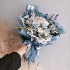 a bouquet of flowers is being held up by someone's hand on a furry surface