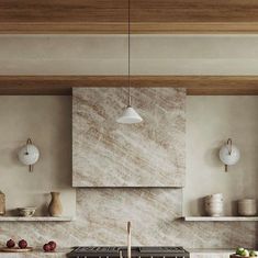 a kitchen with marble counter tops and wooden shelves on the wall, along with hanging lights