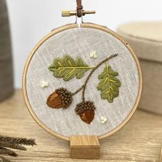 an embroidery project with acorns and leaves