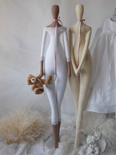 two mannequins are standing next to each other with teddy bears in their arms