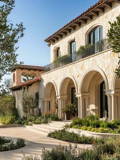 an outdoor courtyard with many plants and trees in the foreground, surrounded by stone arches