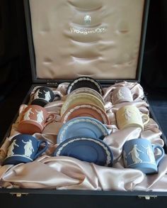 an open suitcase filled with lots of different types of cups and saucers in it