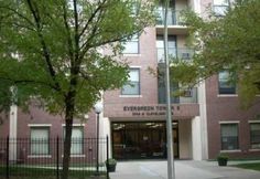 the entrance to an apartment building with trees in front