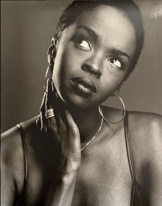 a black and white photo of a woman with large hoop earrings on her neck looking up at the camera