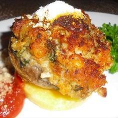 two different types of food on a white plate with parsley and tomato garnish