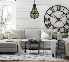 a living room filled with furniture and a large clock on the wall