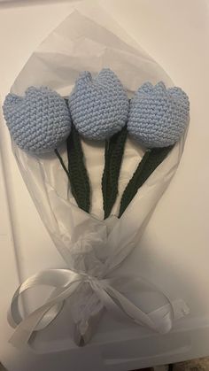 three crocheted blue flowers in a bouquet