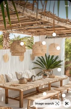 an outdoor seating area with wicker furniture and palm trees on the wall behind it