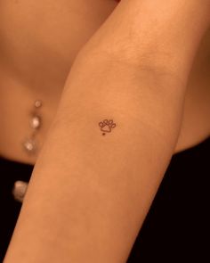 a woman's arm with a small clover tattoo on the left side of her arm