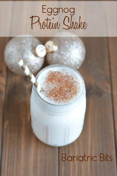 there is a drink in a glass on the table with two silver ornaments behind it