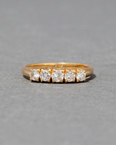 a gold ring with five diamonds on it