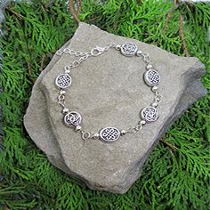 a silver bracelet sitting on top of a rock