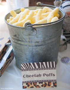 a bucket full of cheetah puffs sitting on top of a table