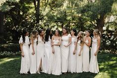 a group of women standing next to each other on top of a lush green field