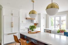 a kitchen with white counters and wooden stools next to an island in the middle