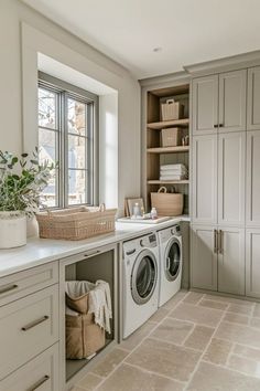 a washer and dryer sitting in a kitchen next to a window with lots of cabinets