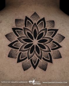 a black and white tattoo design on the back of a man's neck