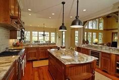 a large kitchen with wooden cabinets and marble counter tops, along with hardwood flooring