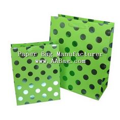 green polka dot paper bag with black dots on the front and bottom, both in different sizes