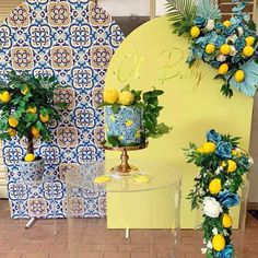 two vases filled with lemons and greenery on top of a table