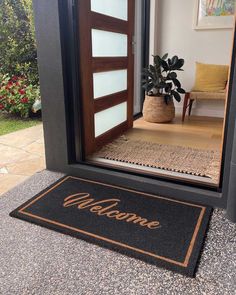 a welcome mat is placed in front of an open door with the word welcome on it