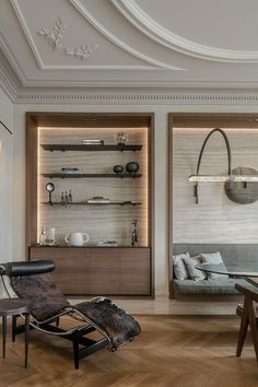 a living room filled with lots of furniture and shelves next to each other on top of hard wood flooring