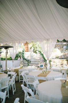 an image of a white tent with tables and chairs