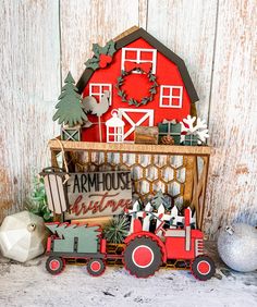 an old fashioned farm scene with a red barn, tractor and christmas tree on display