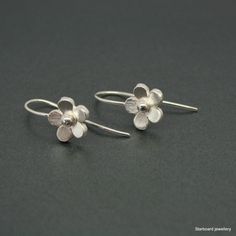 Hand made sterling silver flower earrings. The silver flowers measure 10mm. in diameter and have been hand  saw pierced from sturdy silver sheet To the centre of each flower there is a small silver bead. The earrings are secured with fixed silver hook fittings. All my jewellery comes in a presentation gift box.  All my designs are hand made and no two are exactly the same. Thank you for visiting. Please note that international shipping fees do not include possible custom charges for your country and you will be solely responsible for payment of these charges.  We are required by law to fully disclose the contents and value of the items in your package for Customs purposes.  Your local customs office will be able to provide you with further information on possible import duties and other ch Sterling Silver Jewelry With 3d Flowers In Silver, Sterling Silver Jewelry With 3d Flower Design, Sterling Silver Drop Earrings For Anniversary, Silver Flower Earrings For Pierced Ears, Delicate Silver Flower Earrings Nickel-free, Delicate Silver Flower Earrings Nickel Free, Handmade Sterling Silver Drop Flower Earrings, Handmade Sterling Silver Flower Drop Earrings, Delicate Silver Nickel-free Flower Earrings