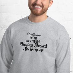 a smiling man wearing a grey sweatshirt with the words, one morning with gratie staying