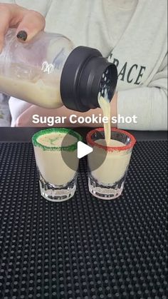 two shot glasses filled with ice cream being poured into one glass and the other is empty