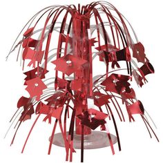 a red sculpture with many pieces of paper hanging from it's sides on a white background