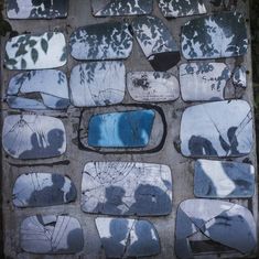 a broken mirror sitting on top of a cement wall