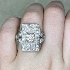 a woman's hand with a diamond ring on top of her finger and an engagement ring in the middle