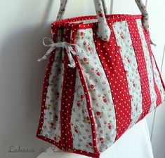 a red and white purse hanging on a wall