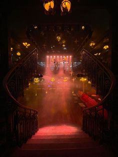 the stairs lead up to an auditorium with lights on them and fog in the air