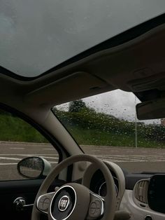 the interior of a car with rain on the windshield