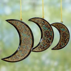 three crescent shaped ornaments hanging from strings