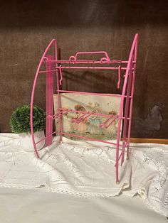 a pink metal magazine rack sitting on top of a bed