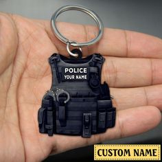 a police officer keychain is shown in the palm of someone's hand