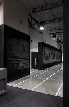 an empty room with black walls and white flooring