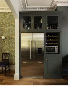 a metallic refrigerator freezer sitting inside of a kitchen next to a wall mounted oven