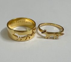 two gold rings with animals on them sitting next to each other