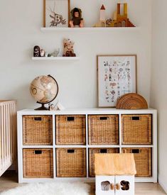 a baby's room with fish wallpaper and wicker baskets on the dresser